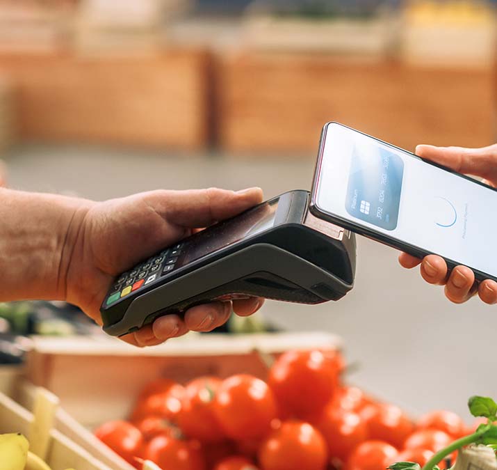 volunteer holding a phone out to pay at a grocery store
