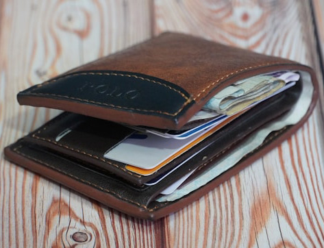 bulging messy wallet full of credit cards and cash