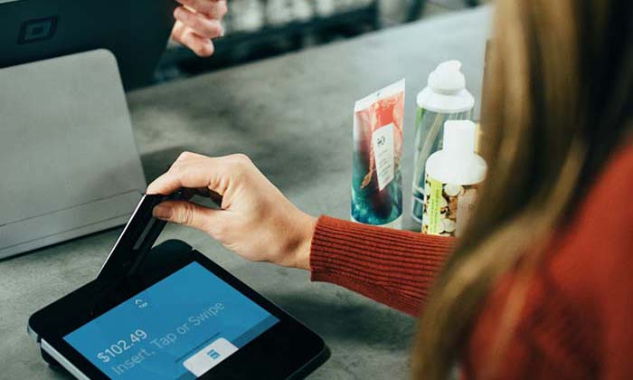 woman using a chip on their debit card to pay