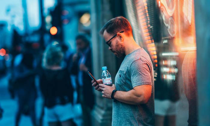 man getting an alert on his phone while out shopping