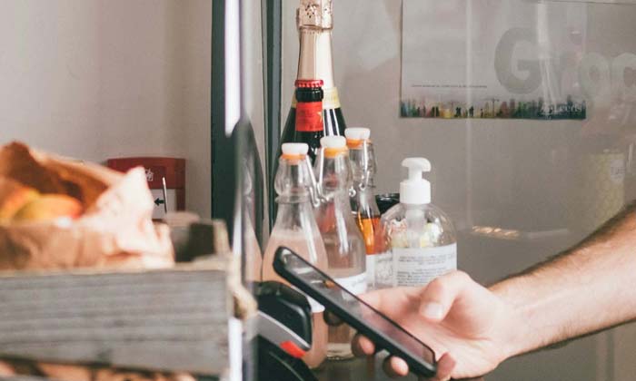 man holding their phone over a pos terminal to pay